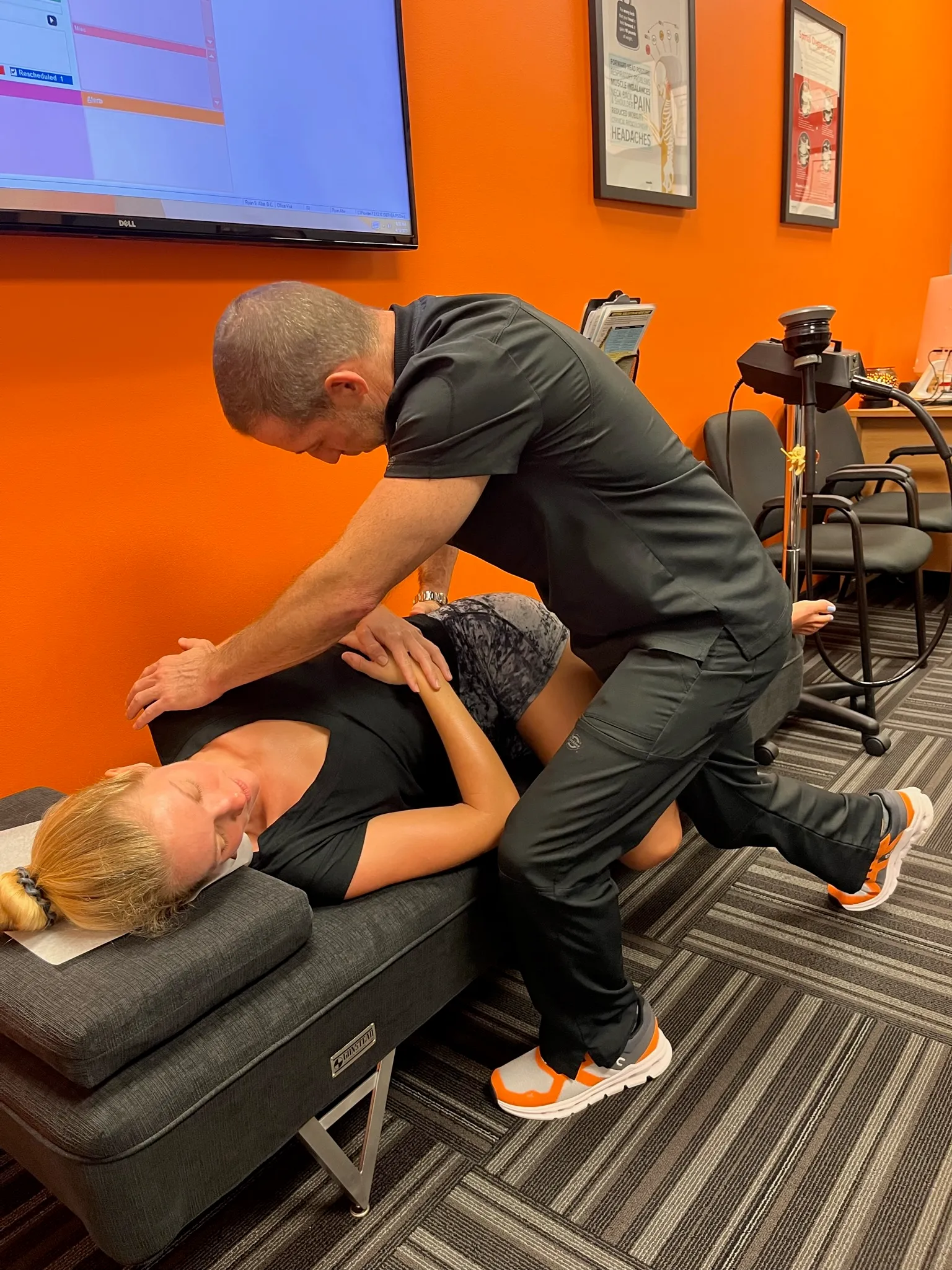 Chiropractor adjusting a patient on an adjusting table