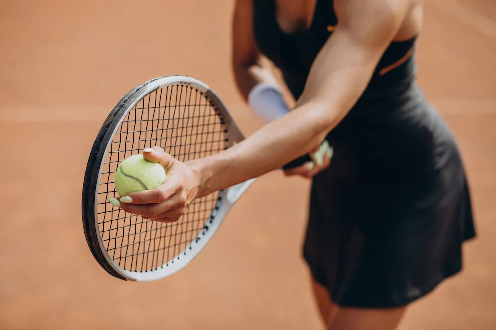 tennis player holding a racket and ball before a serve