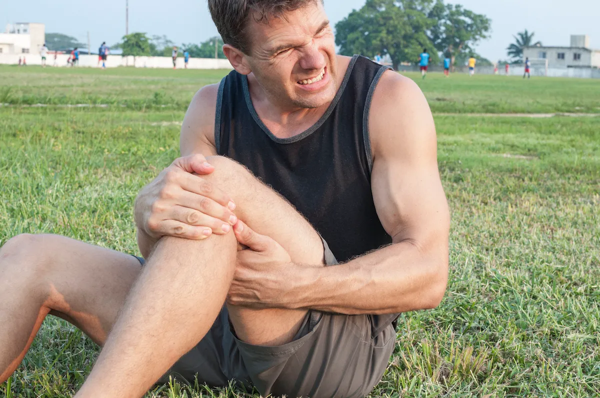 athletic man suffer from knee sprain injury